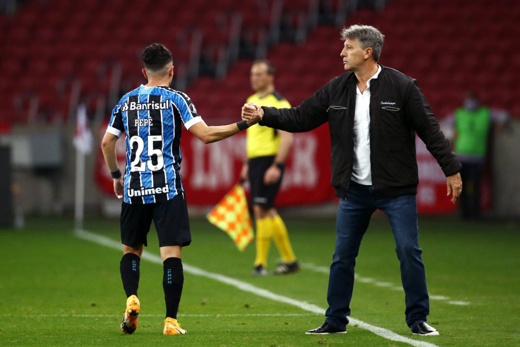 PORTO ALEGRE, BRAZIL - SEPTEMBER 23: Pepê of Gremio celebrates with Renato Portaluppi head coach of Gremio after scoring the the first goal of his team during a group E match of Copa CONMEBOL Libertadores 2020 between Internacional and Gremio at Beira-Rio Stadium on September 23, 2020 in Porto Alegre, Brazil. All games of the tournament are played behind closed doors to avoid spread of COVID-19.  (Photo by Diego Vara-Pool/Getty Images)